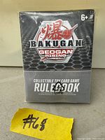 Front view of sealed Bakugan Geogan Rising card game pack showing logo, rulebook text and age 6+ marking