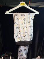 Full view of grey Harry Potter printed lounge pants hanging on hanger
