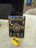 Front of boxed Harry Potter playing cards showing Hogwarts crest and house emblems