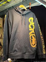 Front view of black Ecko Unltd. hoodie showing yellow logo graphics