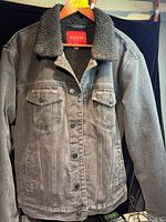 Front view of charcoal denim Guess jacket on hanger