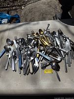 pile of assorted stainless steel flatware on table