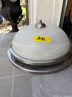 Fixture showing stainless base, frosted glass dome, finial