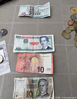 Group of four banknotes with partial view of coin assortment