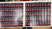 Overview of approximately 100 NARS Explicit Lipstick sample cards laid out on table