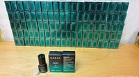 Wall of roughly 100 boxed MBNTL Classic adhesive units on table