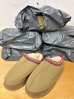 Six packages of slippers with one pair unbagged showing design