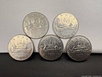 Five 1975 Canadian Voyageur dollars front view