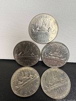 Group shot of all five 1975 Canadian Voyageur dollar coins