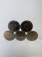 Front view of five 1975 Voyageur dollars