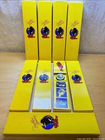 Eight yellow promo boxes, one open showing watch and insert