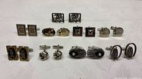 Group shot of eleven pairs of vintage cufflinks on table