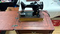 Singer 99K sewing machine mounted in wooden cabinet