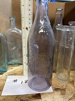 Embossed Providence Brewing Co. amethyst bottle with ruler for scale