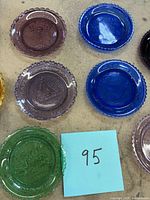 Group of seven plates in various colours with sticky note 95 visible