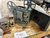 Full lot showing Argus projector with cord, Bell & Howell camera, Revere camera