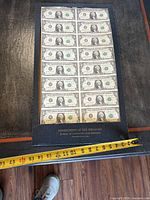 Full view of framed uncut sheet on table with tape measure showing size