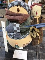 Snowman and rag doll side by side with ruler for scale