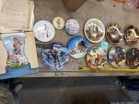 Overview of twelve plates laid out on bench showing variety and scale