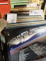 Stack of LP records in crate showing multiple spine edges and one full back cover of K-Tel Night Flight
