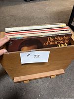 Front view of record lot in wooden holder showing several LP sleeves, foremost Andy Williams album