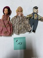 Three dolls side by side displaying size comparison and outfits