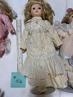 Central cream floral dress doll with ruler and stand