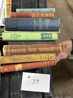 Stack of seven decorative cloth books showing spines and titles