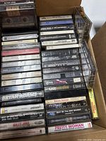 Top box with rows of audio cassette tapes showing artist labels
