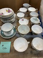 Group of assorted teacups and saucers on table
