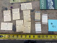 Reverse sides of small cigarette cards and slim fact cards with measuring tape for scale