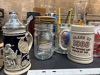 Front lineup showing steins, mason-jar mug, Hard Rock pilsner, Class of 1988 stein