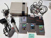Console, controllers, Zapper, power adapter, cable, five visible cartridges plus two in sleeves