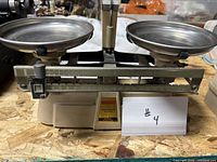 Front view showing complete balance scale with both pans and beam