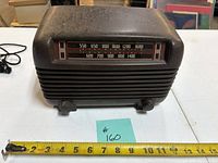 Front view showing radio face, knobs, dial scale and tape measure indicating width