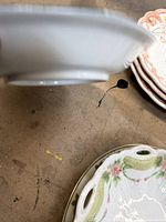 Side view of white footed serving bowl and oval handled dish on table