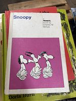 Front cover of Snoopy: A Peanuts Book showing illustrated dancing Snoopy figures