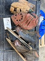 Lot overview showing both skates, tan glove, red catcher’s mitt