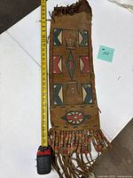 Full view of pouch with measuring tape showing length and front design