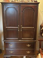 Front view closed showing doors, drawers, brass pulls