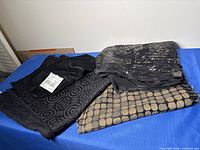 Group of three patterned black fabrics on table