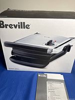 Front of boxed Breville Panini Grill showing product image and branding