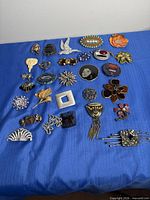All brooches laid out on blue cloth