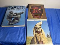 Overview of all three books laid out on blue surface