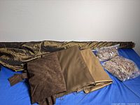 All fabrics laid out: quilted roll, folded pieces, bagged remnants