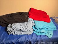 Stacked fabrics showing black, red, aqua blue and light grey-blue pieces