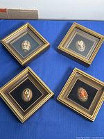 All four framed eggs on blue surface