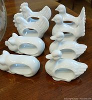 Eight white porcelain animal-shaped napkin rings displayed on table