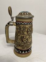 Left profile showing raised frontier scene and handle with thumb lift