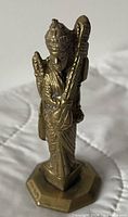 Front view of brass Hindu deity figurine on hexagonal base